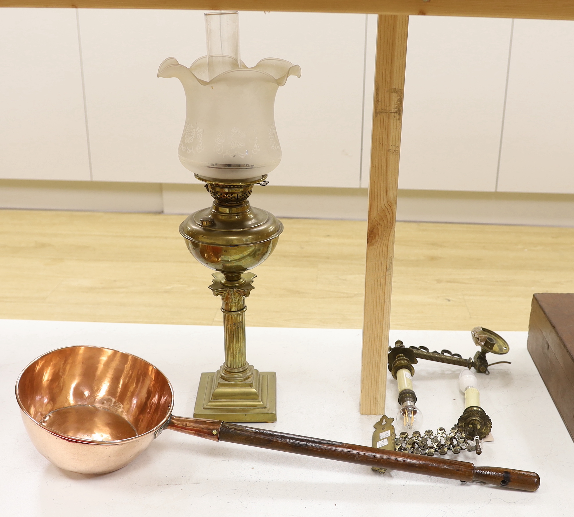 A brass Corinthian column oil lamp, two brass wall sconces and an 1823 copper saucepan